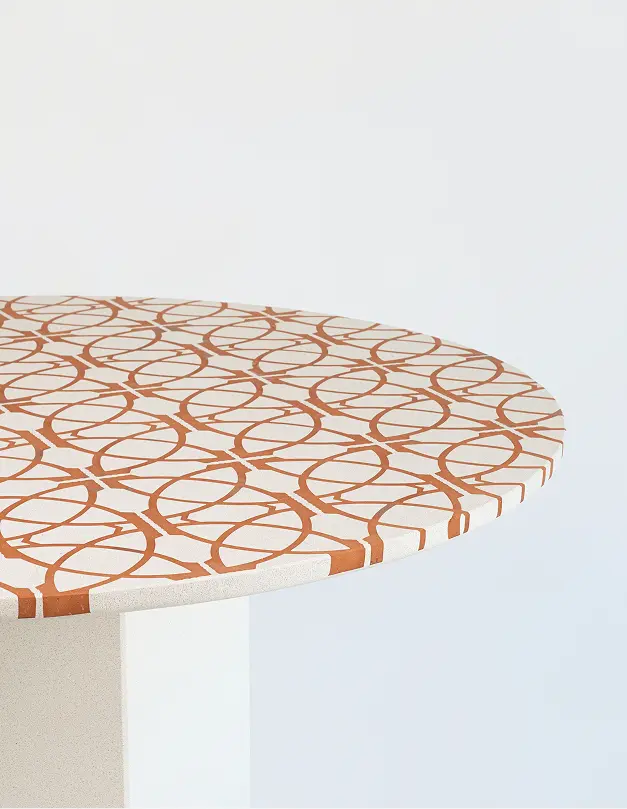 Tavolo Ortigia con piano in cotto e base conica decorata con intarsi geometrici.