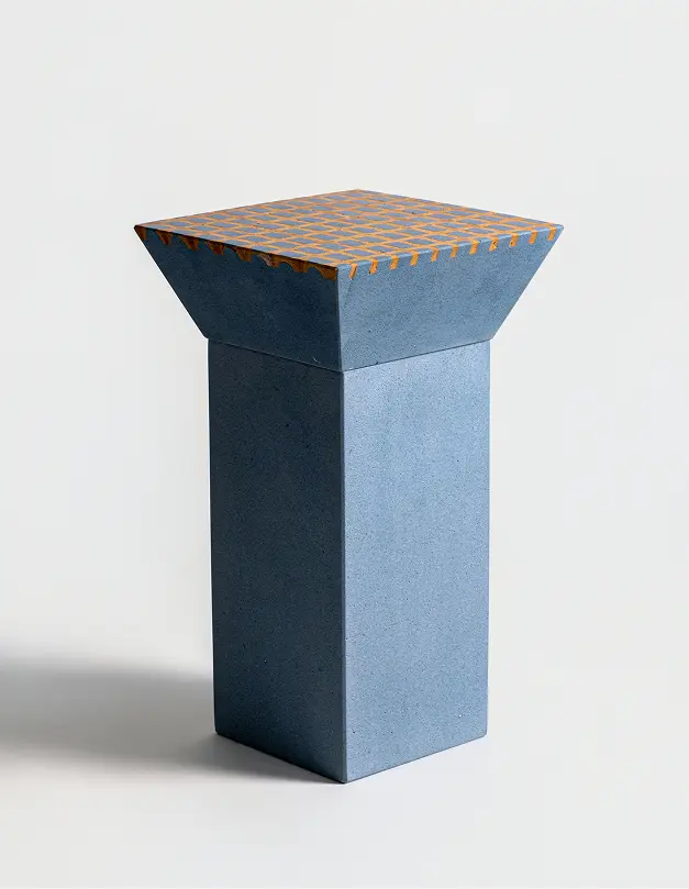 Sgabello quadrato con piano in cotto e base conica decorata con intarsi geometrici.
